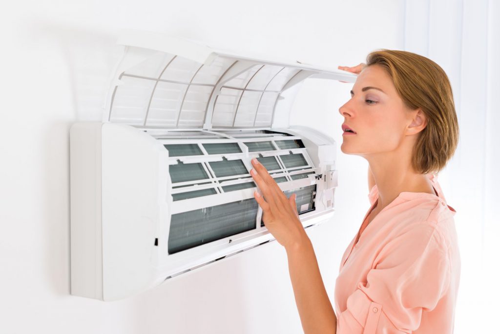 Mulher revisando filtro do ar-condicionado