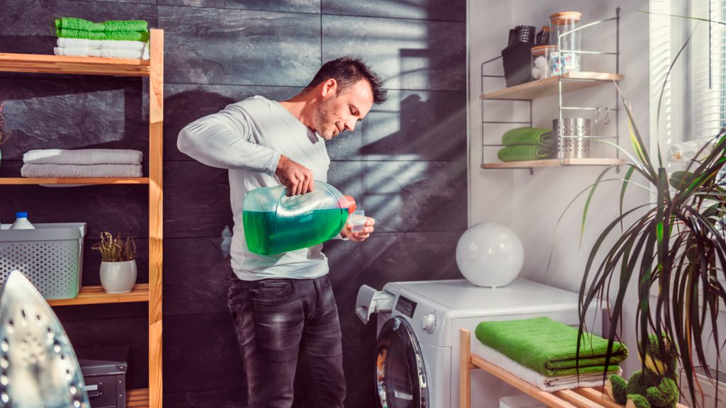 homem lavando roupa na máquina de lavar