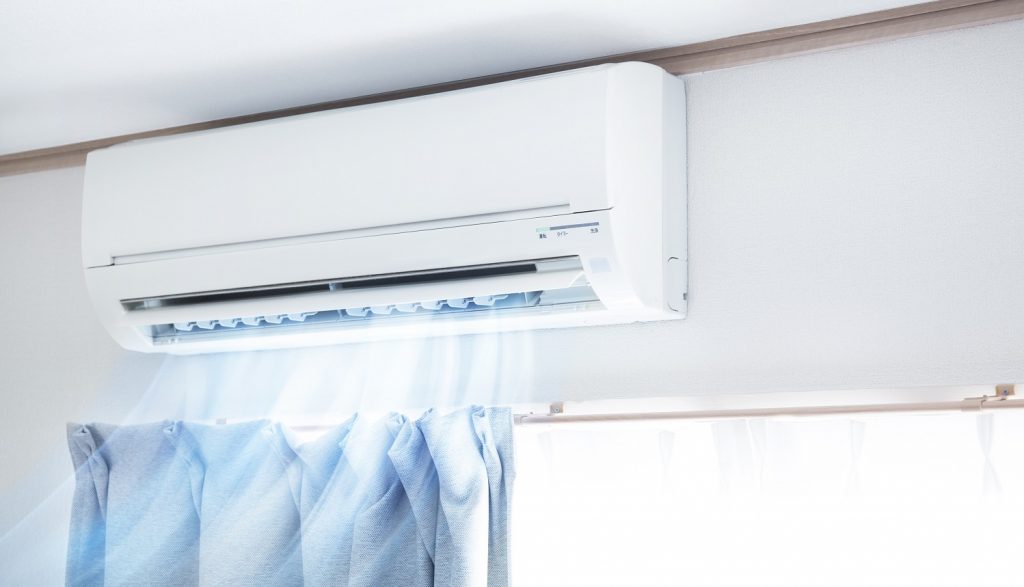 modelo de ar-condicionado com maior custo-benefício localizado na parede, próximo ao teto, emitindo ar frio