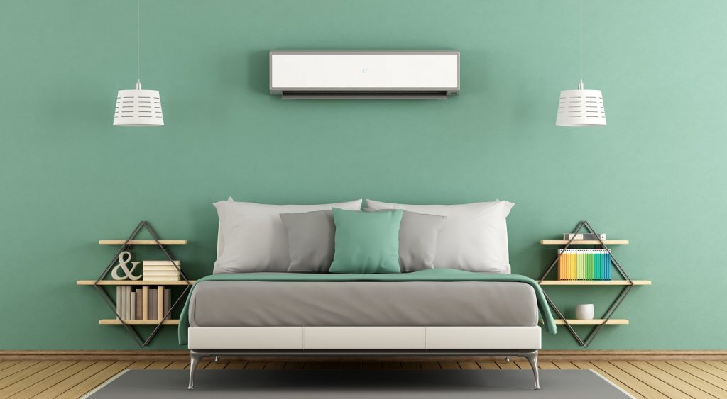 ar-condicionado em quarto de casal com cama encostada na parede e mesas de cabeceira de ambos os lados